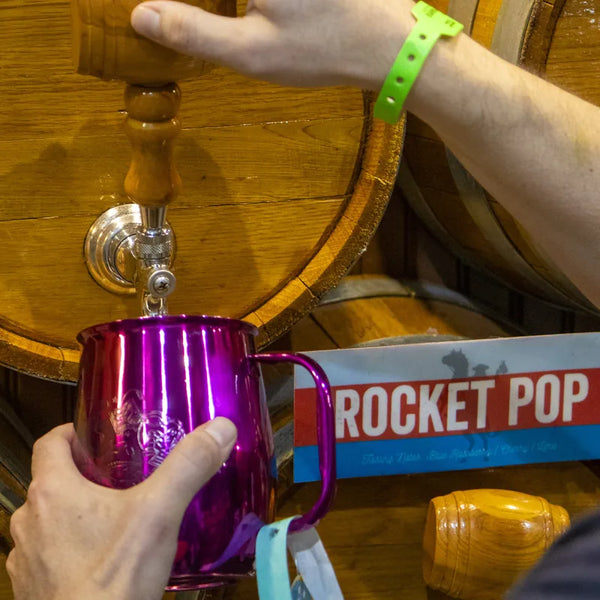 Fan filling a pink Wild Bill's mug with root beer from a barrel tap.